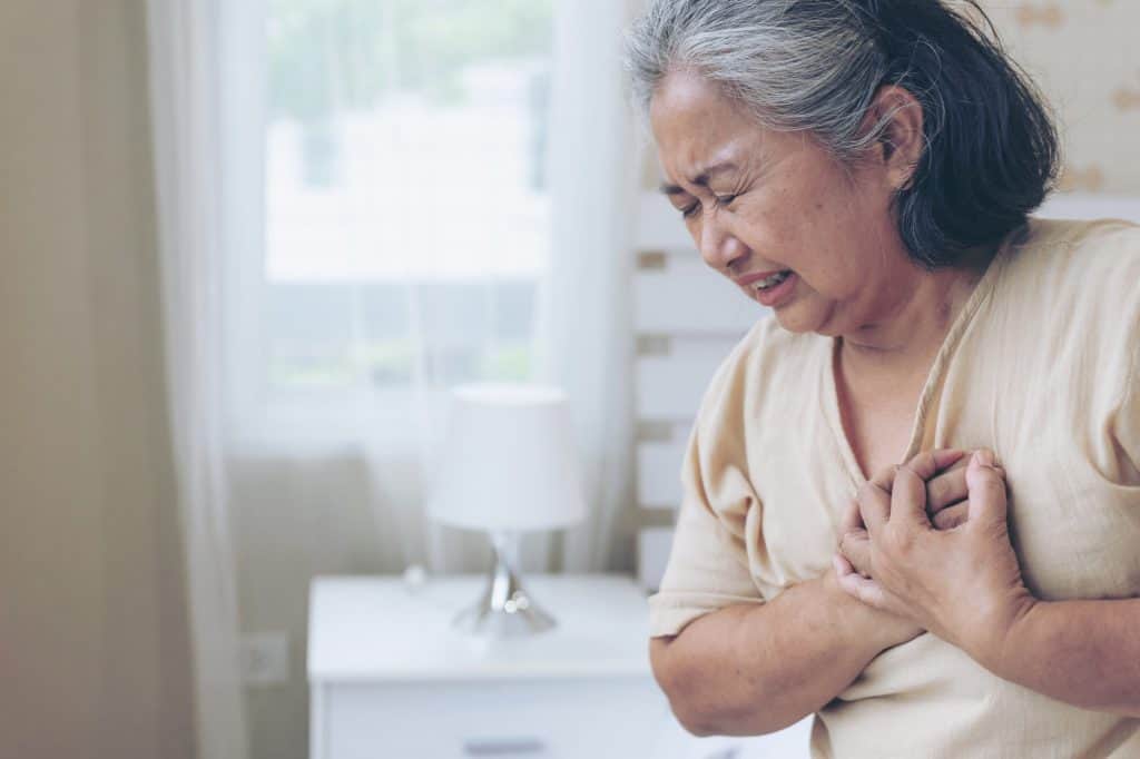 senior female asian suffering from bad pain in his chest heart attack at home senior heart disease